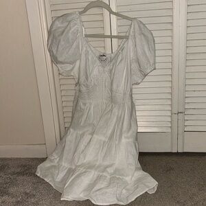 White flowy dress, triangular shaped scrunch in the middle, semi puffy sleeves